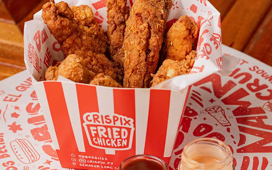 Strips de pollo Crispix en su caja a rayas, con salsas